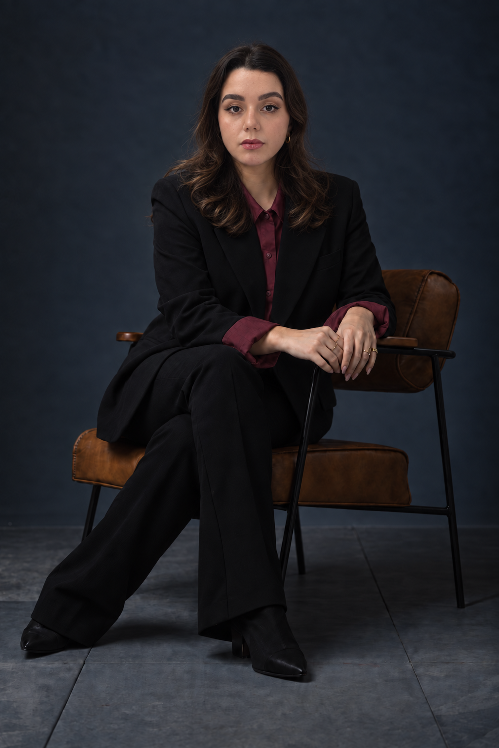 Mellysa Duarte, advogada, em retrato profissional com terno preto e camisa vinho.